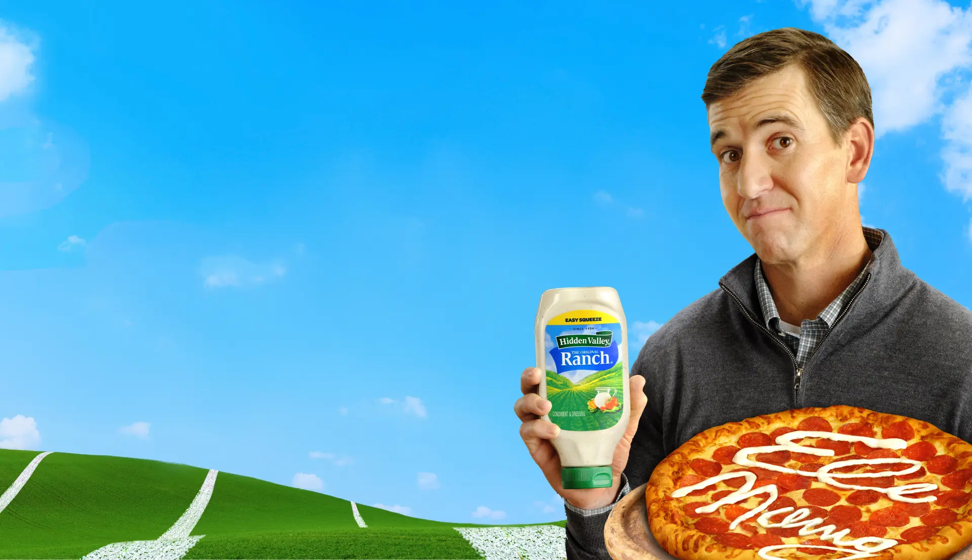 Eli Manning holding a Hidden Valley® Ranch Easy Squeeze bottle and pizza